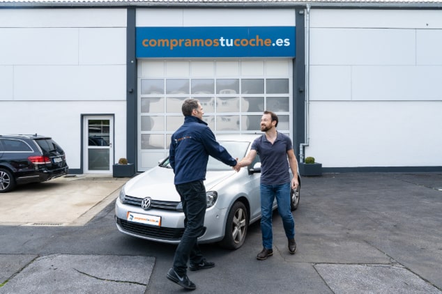 Entregar un coche Cliente satisfecho estrecha la mano al vendedor